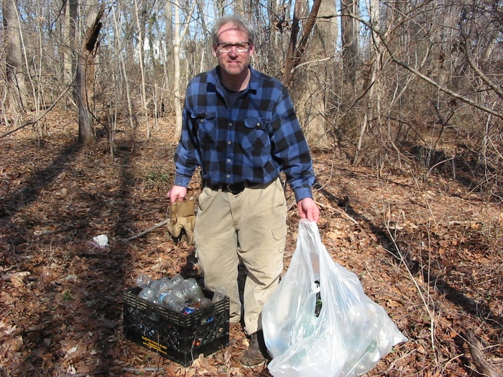 Sean Solomon proudly displays his recently gathered trash from the forest floor.  Morris Park, Philadelphia